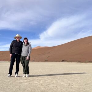 Two women standing in front of a dune.