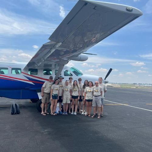 A large family boarding a light aircraft while traveling in Africa.