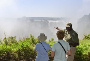 A guide talking about Victoria Falls, on the border of Zimbabwe and Zambia