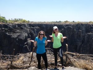 Two women standing by Victoria Falls with no water