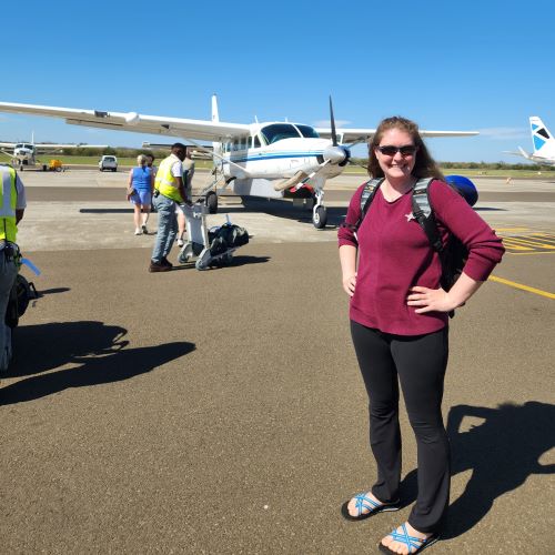 A woman about to get on a light aircraft.