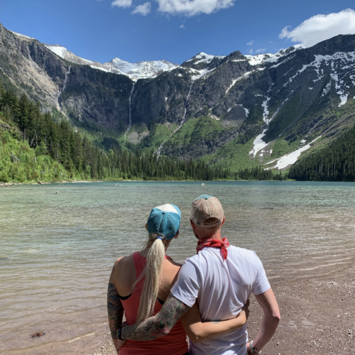 A couple looking at a lake and mountains.