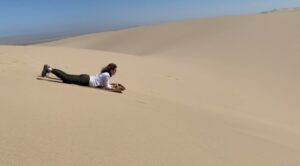 Woman dune boarding, Skeleton Coast, Namibia