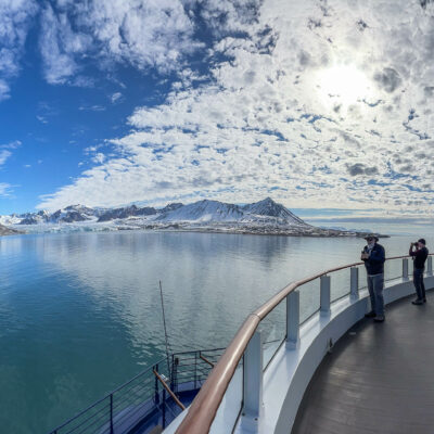 People looking at Svalbard, Norway, from the deck of a ship.