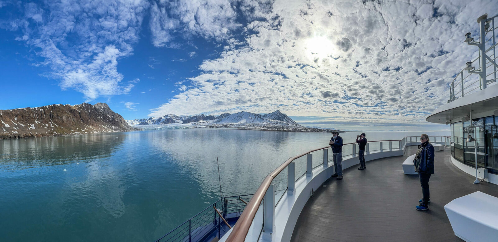 People looking at Svalbard, Norway, from the deck of a ship.