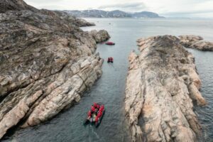 Zodiac cruising between two cliffs.