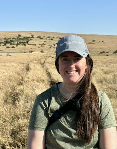 Katie in Kenya with rhinos in the background.