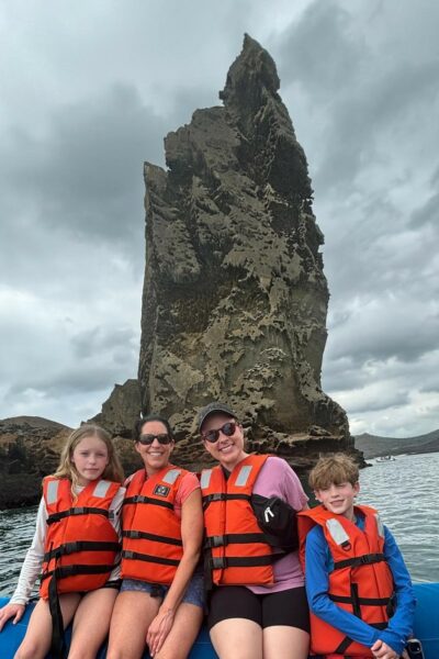 A group of tourists on a Zodiak in front of Pinnacle Rock in the Galapagos Islands.