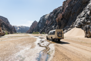 Safari vehicle driving in a valley, Skeleton Coast, Namibia